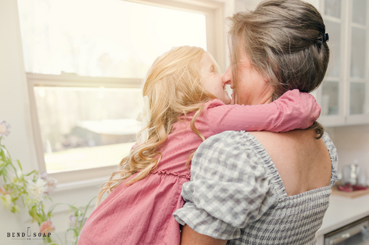 Natural Dish Soap for a Nontoxic Kitchen | Mother and daughter hugging in the kitchen